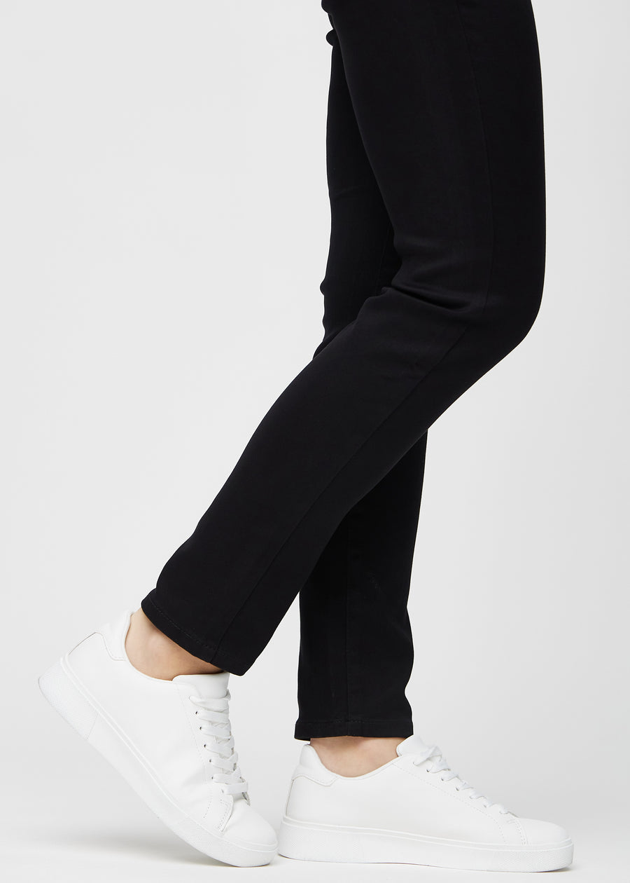 Die Knöchel eines Models, sodass man sehen kann, wie eng die Jeans in einer Slim Passform anliegen.