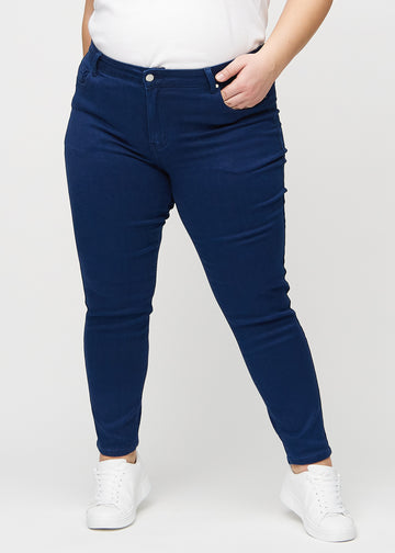 Slim-Jeans für Damen in Dunkelblau, Farbe Royals. Vorderansicht an einem Plus-Size-Model, körpernah geschnitten mit etwas mehr Platz am Knöchel.
