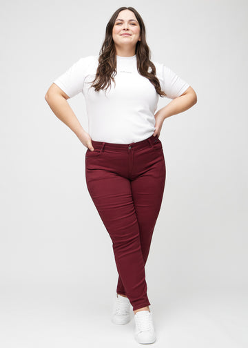 Slim-Jeans für Damen in Dunkelrot, Farbe Santas. Ganzkörperansicht eines Plus-Size-Models in den Jeans.