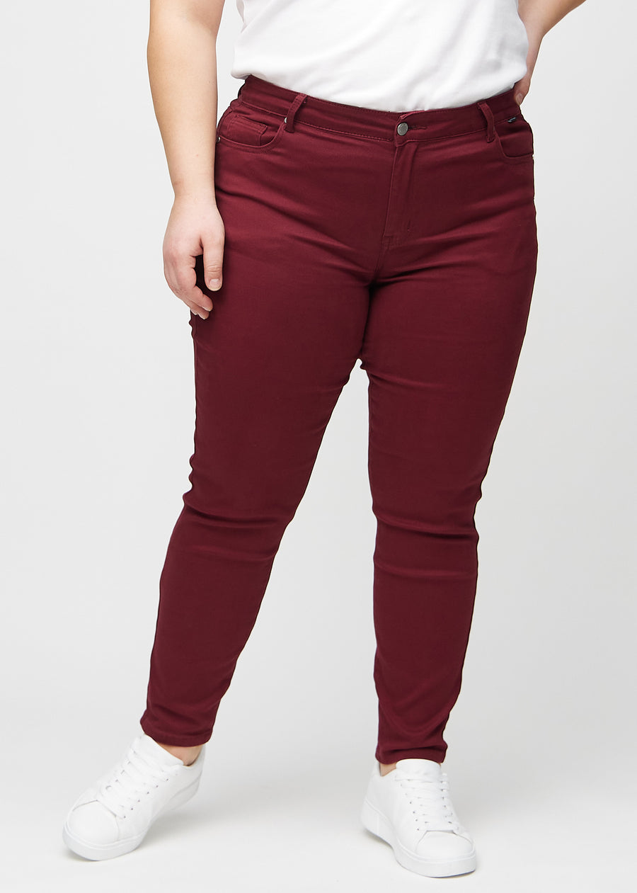 Slim-Jeans für Damen in Dunkelrot, Farbe Santas. Vorderansicht an einem Plus-Size-Model, körpernah geschnitten mit etwas mehr Platz am Knöchel.