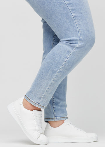 Slim-Jeans für Damen in Hellblau, Farbe Waves. Nahaufnahme an den Knöcheln eines Plus-Size-Models, um die Passform am Beinabschluss zu zeigen.