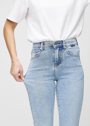 Slim-Jeans für Damen in Hellblau, Farbe Waves. Ein Model zieht am Jeansstoff am Oberschenkel, um den Stretch zu zeigen.