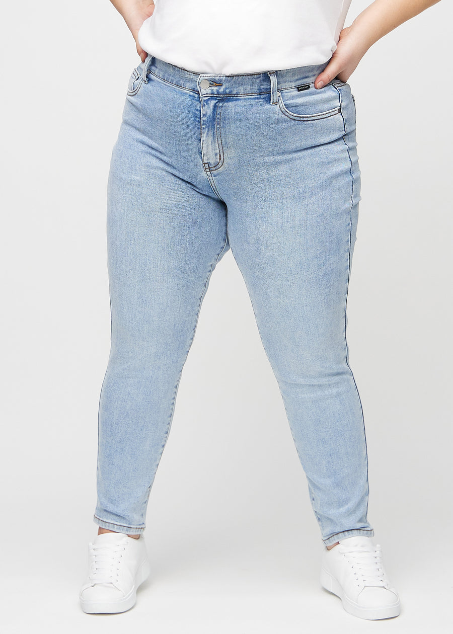 Slim-Jeans für Damen in Hellblau, Farbe Waves. Vorderansicht an einem Plus-Size-Model, körpernah geschnitten mit etwas mehr Platz am Knöchel.