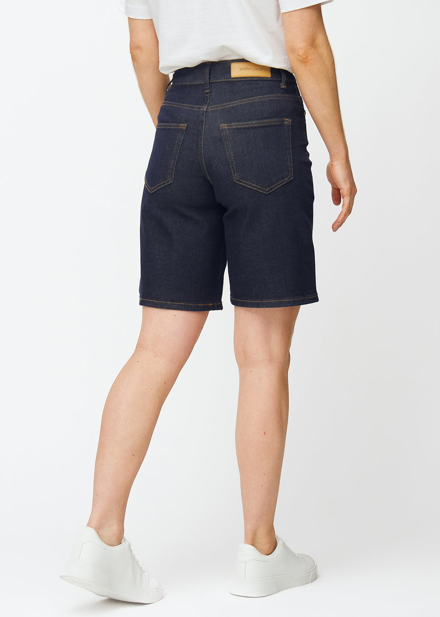 Tief dunkelblaue Denim-Shorts für Damen in der Farbe Midnights von hinten gesehen, sodass die Länge bis knapp über das Knie sichtbar ist.