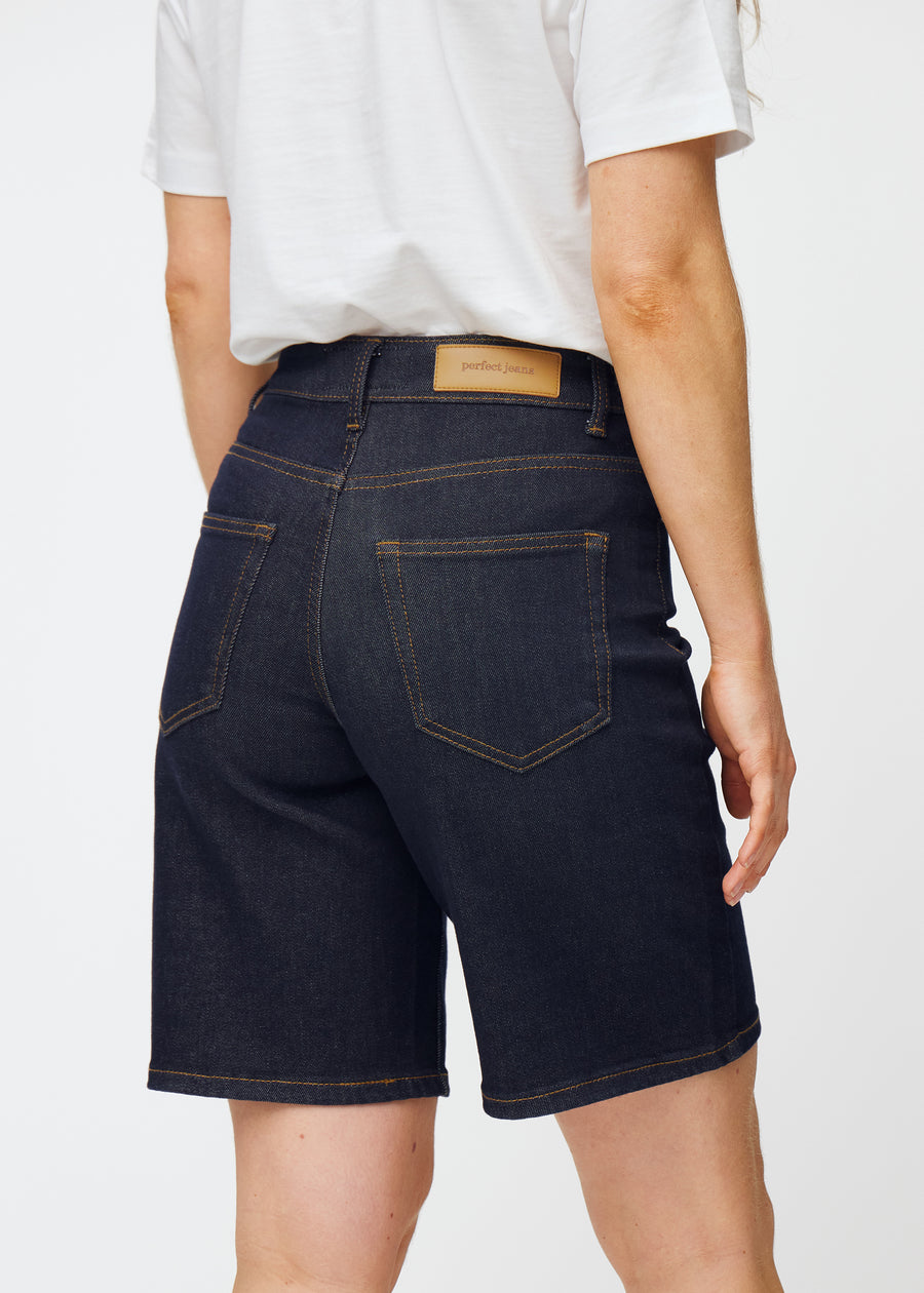 Tief dunkelblaue Denim-Shorts für Damen in der Farbe Midnights von hinten nah aufgenommen, um Passform und Details zu zeigen.