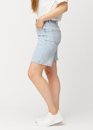 Lyseblå denimshorts til kvinder i farven Waves med middle waist og loose pasform set fra siden på model.