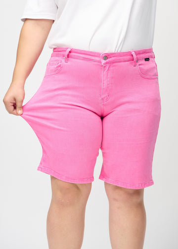Das Plus-Size-Model zieht die Shorts am Oberschenkel auseinander, um den Stretch zu zeigen.
