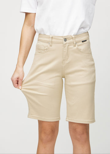 Das Model zieht die Shorts am Oberschenkel auseinander, um den Stretch zu zeigen.