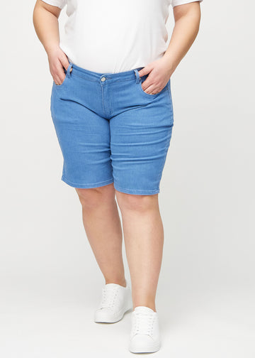 Blaue regular Middle Shorts, Modellname Geraniums, die gerade am Bein herunterfallen und bei einem Plus-Size-Model knapp über dem Knie enden, von vorne gesehen.