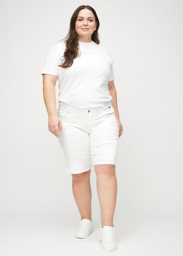 Ganzkörperbild eines Plus-Size-Models in weißen regular Middle Shorts.