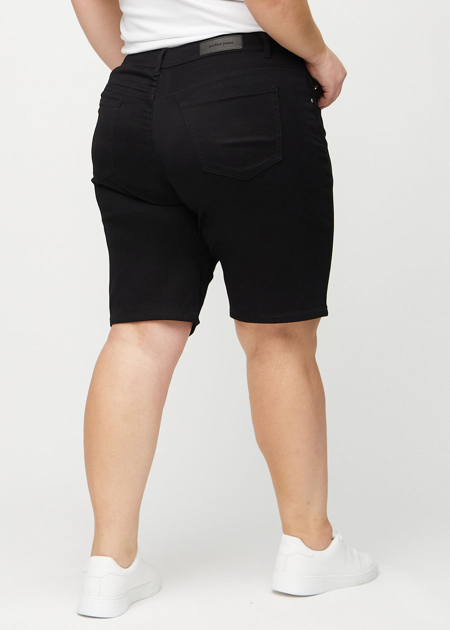 Schwarze regular Middle Shorts von hinten an einem Plus-Size-Model gezeigt, sodass man das gesamte Produkt sehen kann.