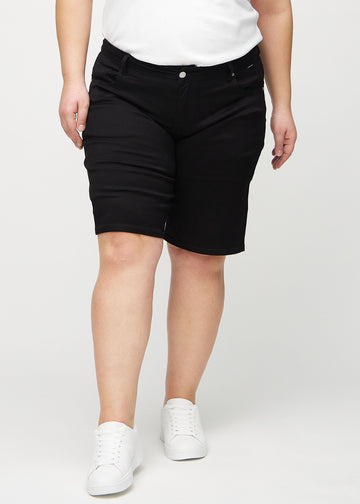 Schwarze regular Middle Shorts, Modellname Ravens, die gerade am Bein herunterfallen und knapp über dem Knie enden, an einem Plus-Size-Model, von vorn gesehen.