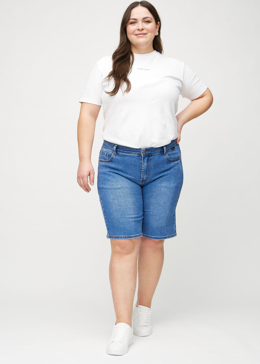 Ganzkörperbild eines Plus-Size-Models in Denim regular middle shorts.