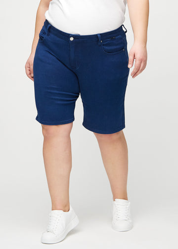 Dunkelblaue regular middle shorts, Modellname Royals, die gerade am Bein herunterfallen und bei einem Plus-Size-Model knapp über dem Knie enden, von vorne gesehen.