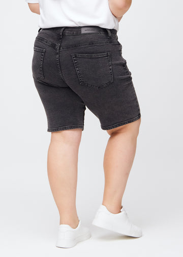 Dunkelgraue Denim-regular-Middle-Shorts von hinten an einem Plus-Size-Model gesehen, sodass man das gesamte Produkt sehen kann.