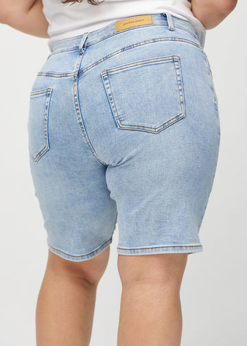 Hellblaue Denim-regular middle shorts von hinten aus der Nähe an einem Plus-Size-Model gesehen, um Details zu zeigen.