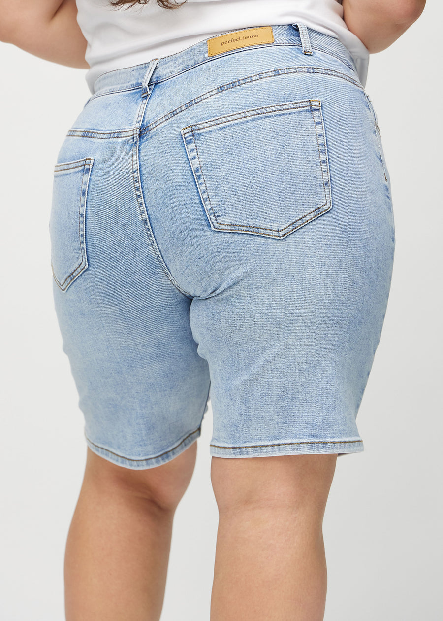 Hellblaue Denim-regular middle shorts von hinten aus der Nähe an einem Plus-Size-Model gesehen, um Details zu zeigen.