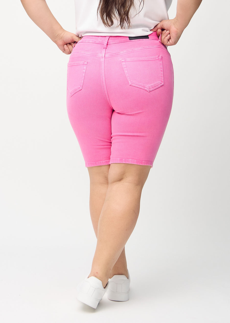 Hellrosa skinny middle shorts von hinten an einem Plus-Size-Model gesehen, sodass man das gesamte Produkt sehen kann.