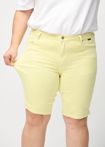 Das Plus-Size-Model zieht die Shorts am Oberschenkel auseinander, um den Stretch zu zeigen.