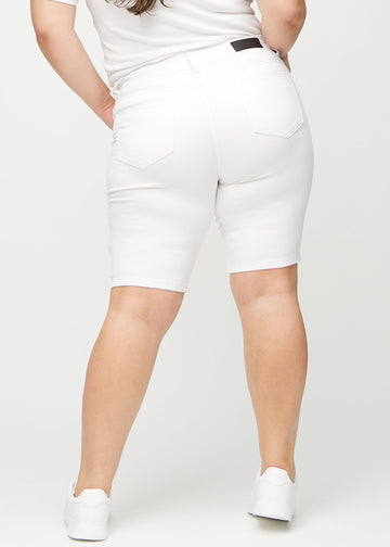 Weiße skinny Middle Shorts von hinten an einem Plus-Size-Model gesehen, sodass das gesamte Produkt zu sehen ist.