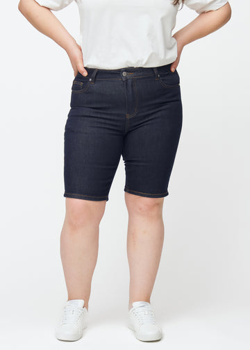 Tief dunkelblaue Denim-Shorts für Damen in der Farbe Midnights mit Skinny-Passform, von vorne auf einem Plus-Size-Model gesehen.