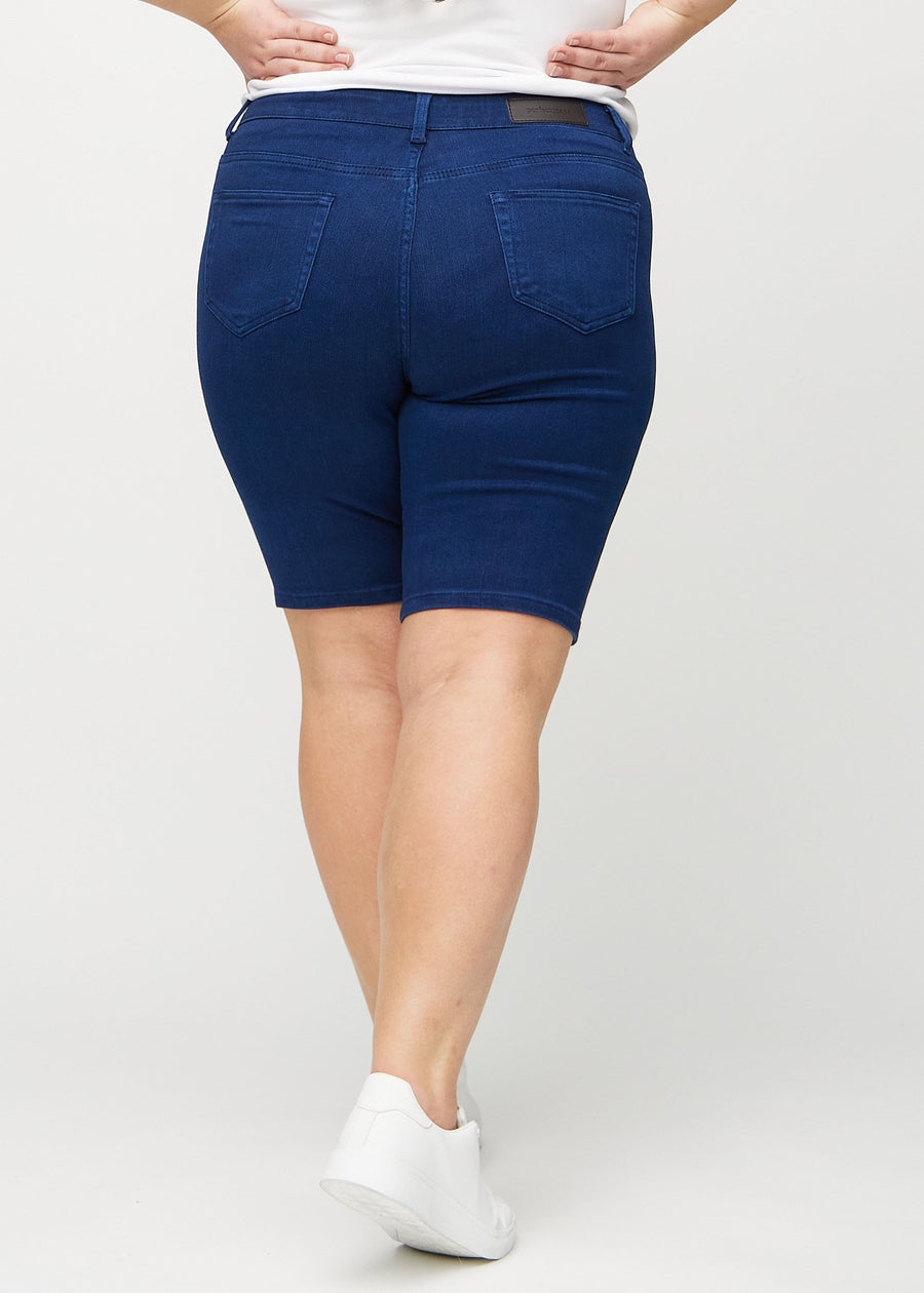 Dunkelblaue skinny middle shorts von hinten an einem Plus-Size-Model gesehen, sodass man das ganze Produkt sehen kann.
