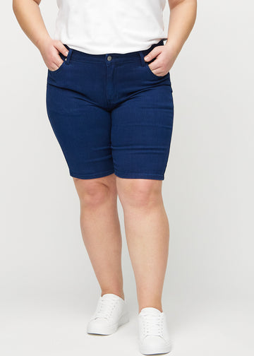 Dunkelblaue skinny middle shorts, Modellname Royals, die eng am Oberschenkel anliegen und knapp über dem Knie enden, an einem Plus-Size-Model von vorne gesehen.