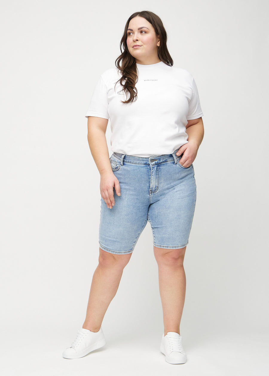 Ganzkörperbild eines Plus-Size-Models in hellen Denim-skinny Middle Shorts.