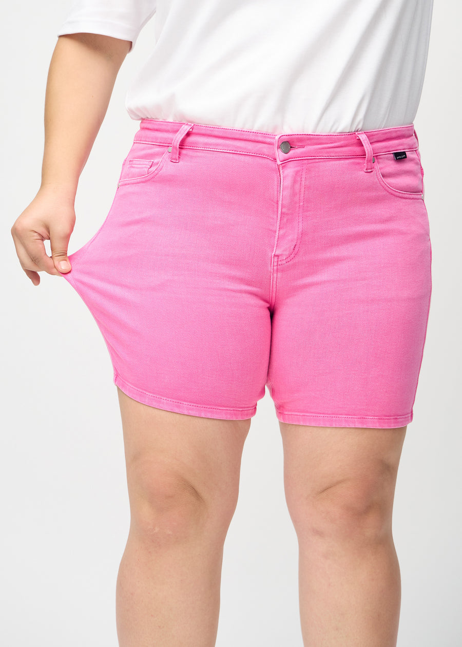 Das Plus-Size-Model zieht die Shorts am Oberschenkel auseinander, um den Stretch zu zeigen.