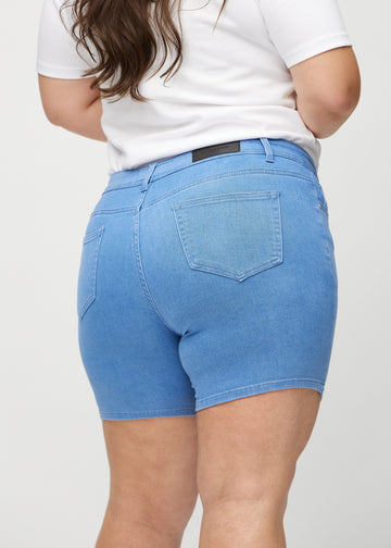 Blaue skinny Short Shorts von hinten in Nahaufnahme an einem Plus-Size-Model, um Details zu zeigen.