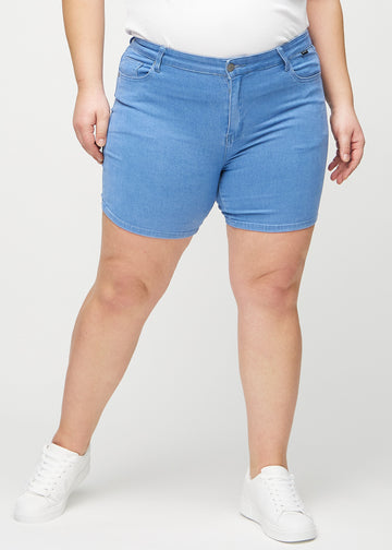 Blaue skinny Short Shorts, Modellname Geraniums, die eng anliegen und bei einem Plus-Size-Model bis zur Mitte des Oberschenkels reichen, von vorne gesehen.