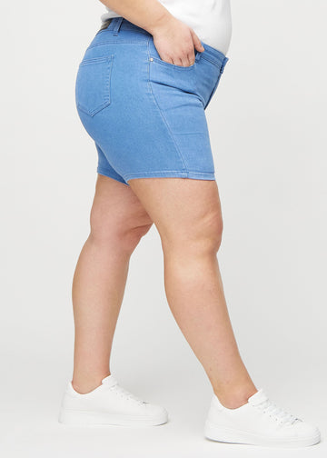 Blaue skinny Short Shorts seitlich an einem Plus-Size-Model gesehen.