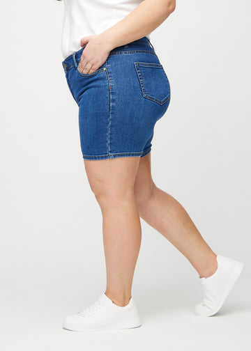 Dunkle Denim-skinny Short Shorts seitlich an einem Plus-Size-Model gesehen.