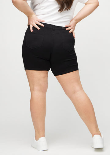 Schwarze skinny Short Shorts von hinten an einem Plus-Size-Model gesehen, damit man das gesamte Produkt sehen kann.