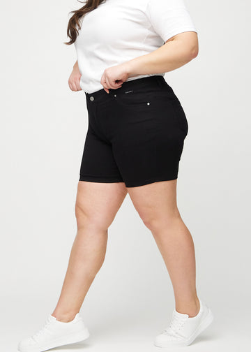 Schwarze skinny Short Shorts von der Seite an einem Plus-Size-Model gesehen.