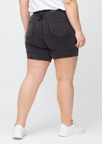 Dunkelgraue Denim-skinny-Short Shorts von hinten an einem Plus-Size-Model gesehen, sodass man das gesamte Produkt sehen kann.