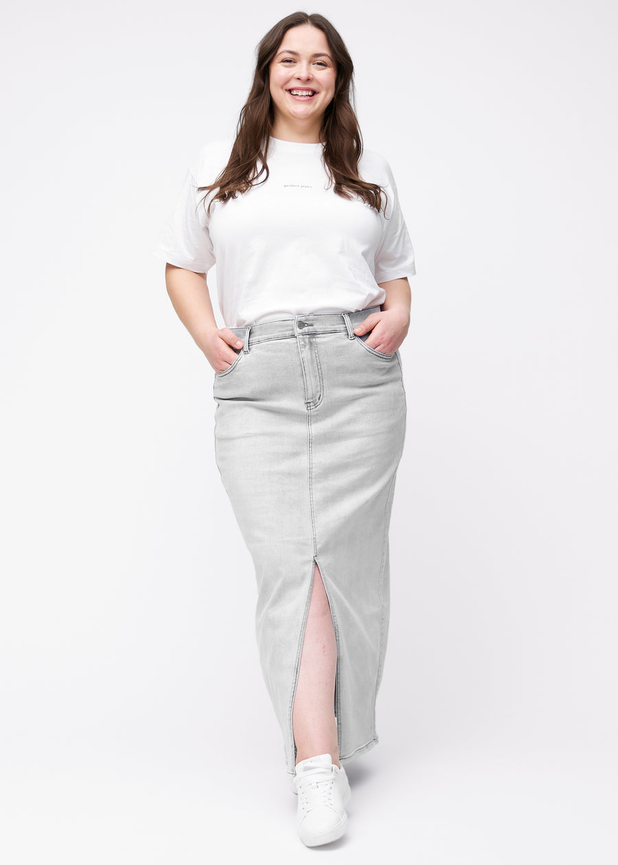 Langer hellgrauer Denimrock für Damen in der Farbe Ashes. Ganzkörperansicht eines Plus-Size-Models in dem Rock mit Schlitz vorne.