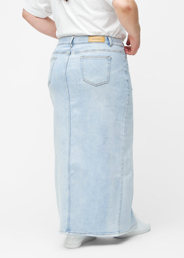 Lang, lyseblå denimnederdel i farven Waves med regulær pasform set bagfra på plus-size model, så hele nederdelens længde kan ses.