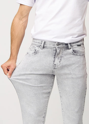Das Model zieht die Jeans am Oberschenkel auseinander, um den Stretch zu zeigen.