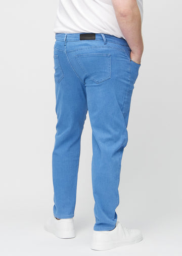 Blaue regular jeans von hinten an einem Plus-Size-Model gesehen, damit man das ganze Produkt sehen kann.