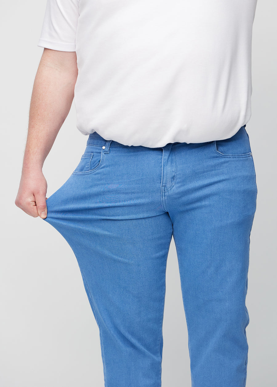 Das Plus-Size-Model zieht die Jeans am Oberschenkel auseinander, um den Stretch zu zeigen.