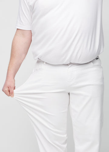 Das Plus-Size-Model dehnt die Jeans am Oberschenkel, um den Stretch zu zeigen.