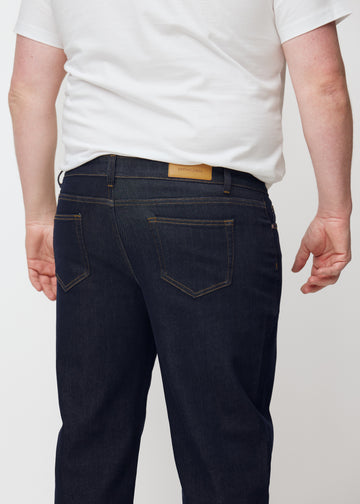Tief dunkelblaue Denim jeans für Herren in der Farbe Midnights von hinten aus der Nähe an einem Plus-Size-Model gesehen.