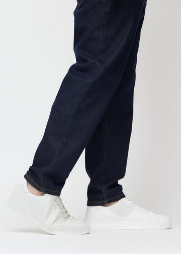 Tief dunkelblaue Denim jeans für Herren in der Farbe Midnights mit regular Passform, aus der Nähe an den Knöcheln an einem Plus-Size-Model gesehen, um den geraden Abschluss zu zeigen.