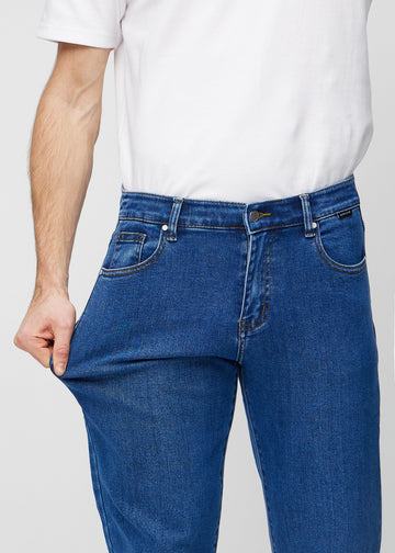 Das Model dehnt die Jeans am Oberschenkel, um den Stretch zu zeigen.