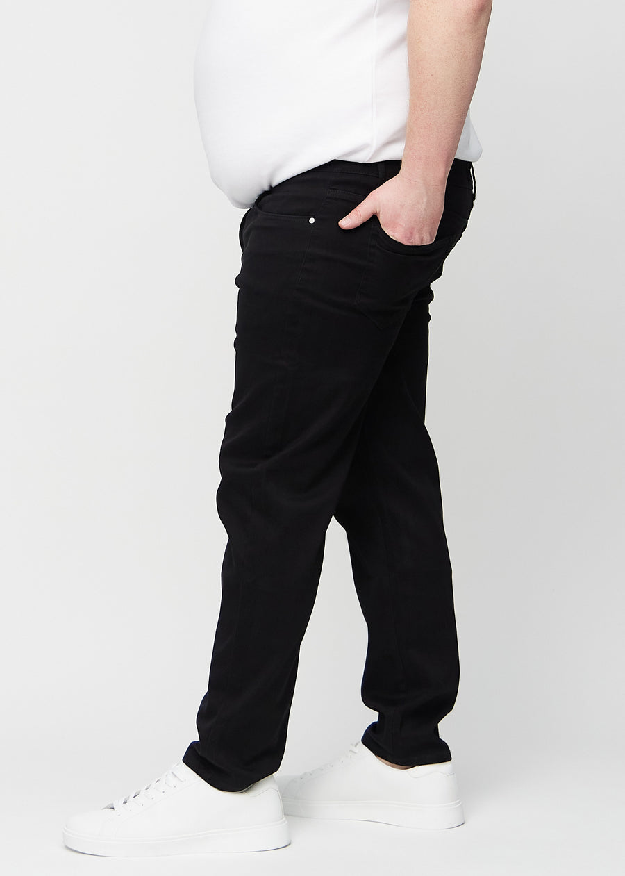 Schwarze regular jeans von der Seite an einem Plus-Size-Model gesehen.