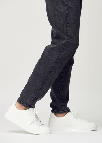 Die Knöchel eines Models, sodass man sehen kann, wie locker die Jeans sitzt.