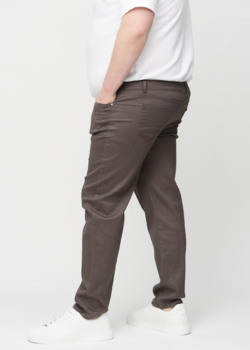 Graubraune regular jeans von der Seite an einem Plus-Size-Model gesehen.