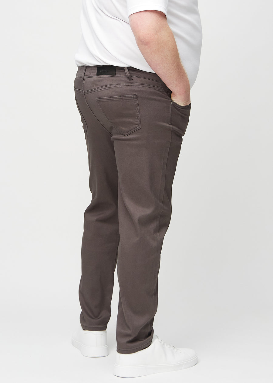 Graubraune regular jeans von hinten an einem Plus-Size-Model gesehen, damit man das gesamte Produkt sehen kann.