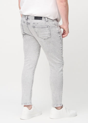 Hellgraue Denim-Jeans im Slim Fit, von hinten an einem Plus-Size-Model gesehen, um die gesamte Jeans zu zeigen.